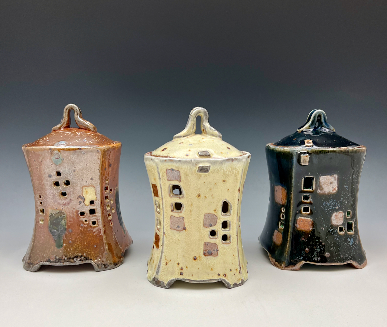 three garlic jars in brown, yellow, and black