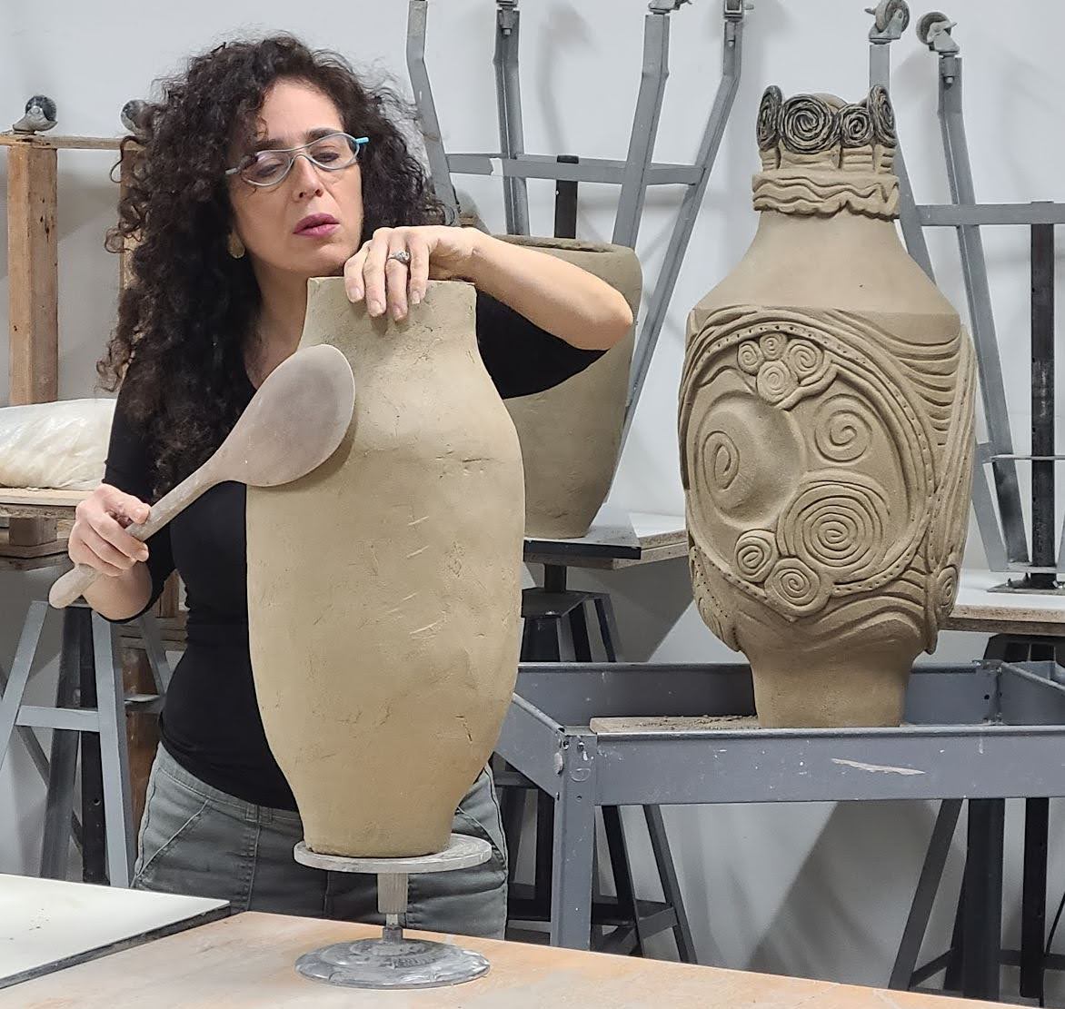 a person making a large vessel out of clay