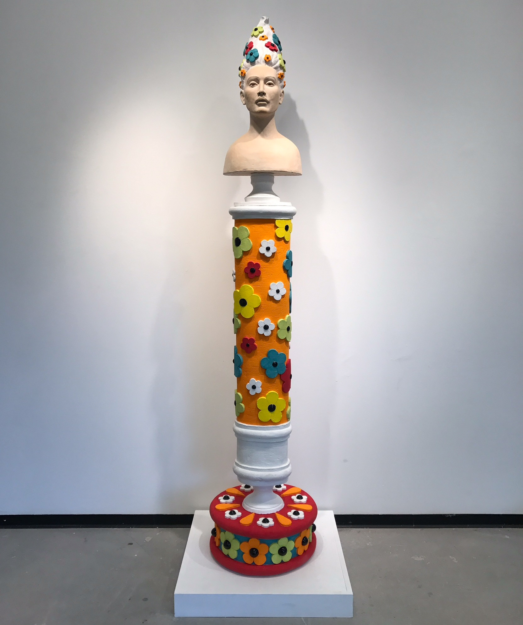 sculptural bust on pedestal covered in flowers