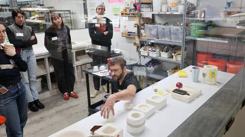 Forrest Sincoff Gard explains slip casting into plaster molds to a group of students