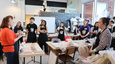 Students take in an explanation of the clay material by Kathy King