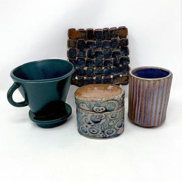 four slab-built pottery items: a coffee-brewing cone, an oval lidded box, a cup, and a woven square plate