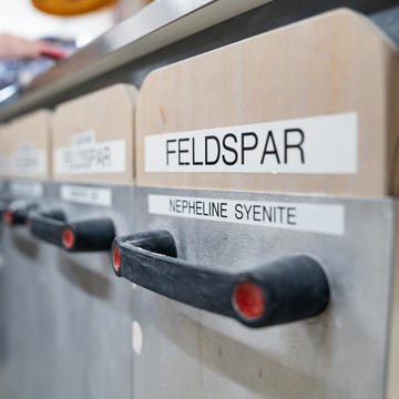 metal bins labeled "Nepheline Syenite" "Feldspar"