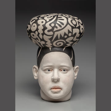 ceramic sculpture of a head with patterned hat