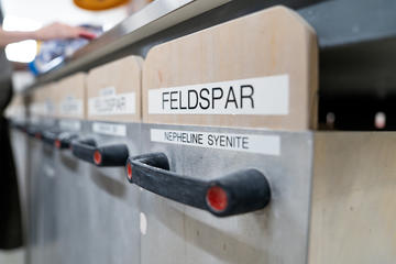bins of raw glaze material labeled "Feldspar"