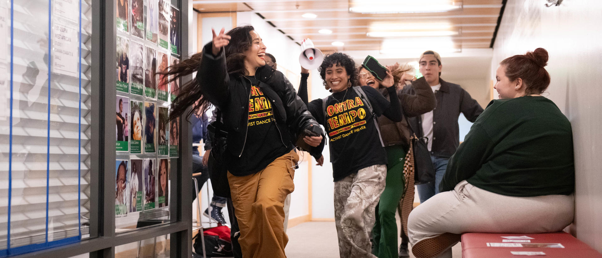 CONTRA-TIEMPO artists joyfully leading a procession through Harvard Dance Center