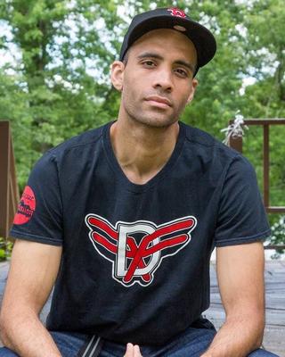 Steve Garcia looking at the camera seated with his hands folded on his knees.