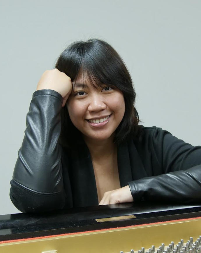 Headshot of Wen-Ting Ong sitting at the piano and smiling at the camera.