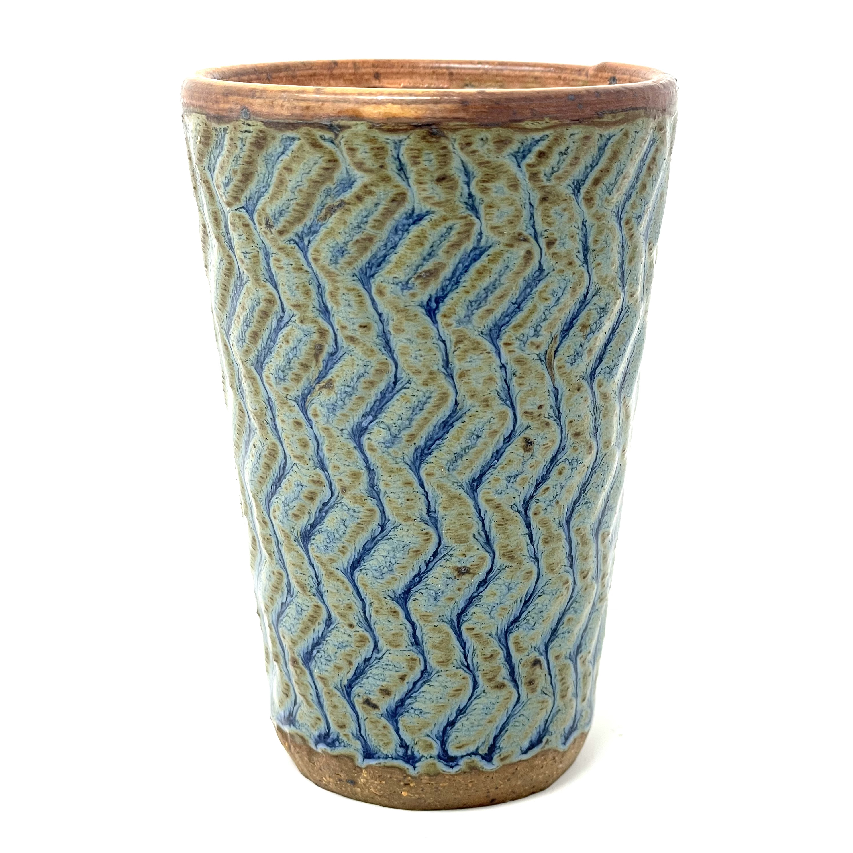 Ceramic tumbler with blue/brown textured glazed surface and brown rim and foot.