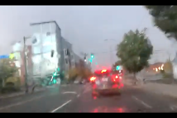 Screenshot from video. Image is of a blurry street with a car braking.