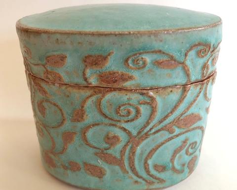 lidded jar with embossed floral image